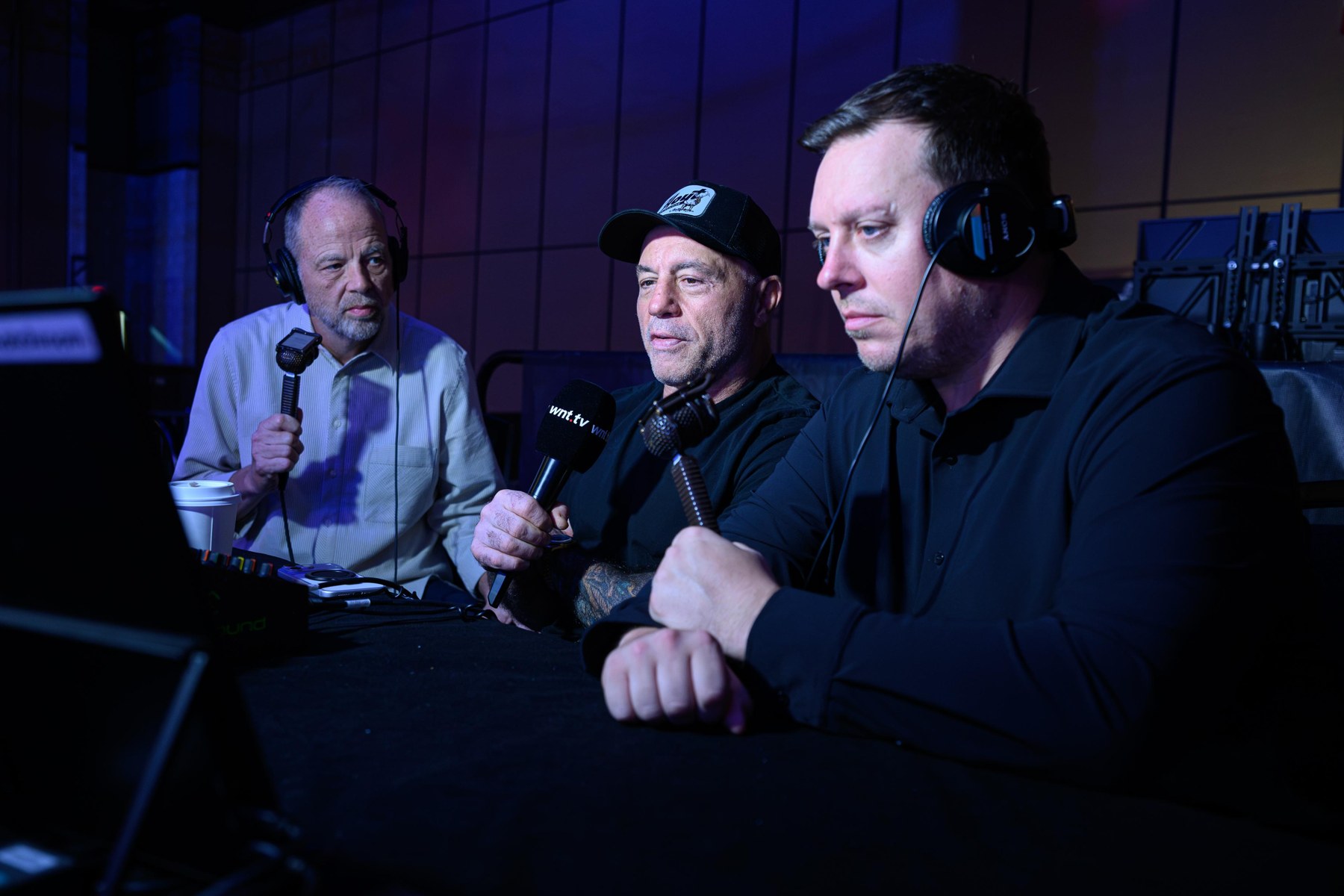 Karl Boyes holding a microphone alongside fellow pool commentators