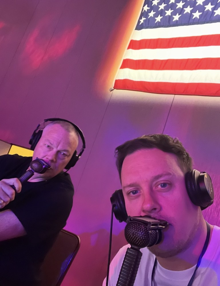 Karl Boyes and a fellow commentator with microphones and headphones