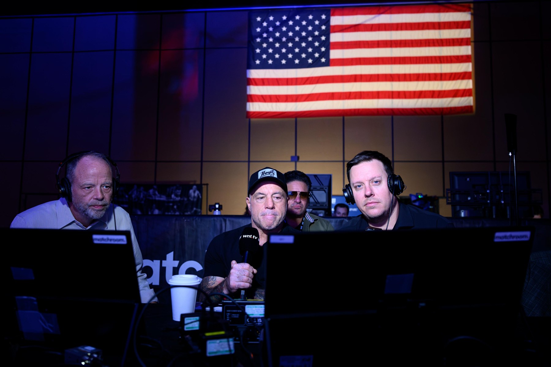 Karl Boyes with fellow commentators wearing headphones behind broadcast monitors